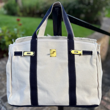 Load image into Gallery viewer, “Boatkin” Canvas Tote Bag w/ Gold Buckle Hardware - ivory with navy trim